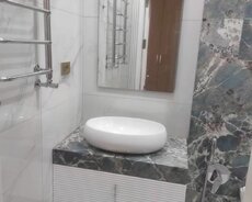 Ağ rəngdə, oval formalı, dəbli lavabo. Dolablı və boz mərmər başlıqlı